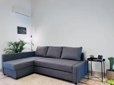 a gray couch in a living room with plants at Orethus Apartment - Exclusive Palermo Center in Palermo