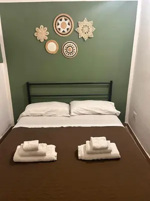a bed with two towels on top of it at GREENHOME in Palermo