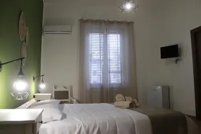 a bedroom with a large white bed and a window at GREENHOME in Palermo