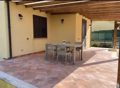 a table and chairs sitting on a patio at Villa indipendente le coccinelle beach mare piscina a 250 mt dal mare con servizio di piscina a 400 mt 12 k da Cefalu in Campofelice di Roccella
