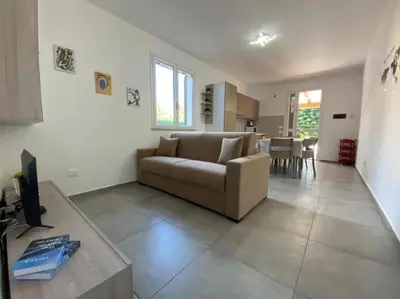 a living room with a couch and a table at Villa indipendente le coccinelle beach mare piscina a 250 mt dal mare con servizio di piscina a 400 mt 12 k da Cefalu in Campofelice di Roccella