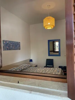 a bedroom with a bed and a chair in it at Belmare trilocale a piano terra indipendente in San Vito lo Capo
