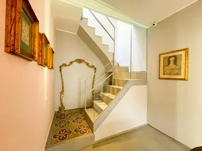 a staircase in a house with a painting on the wall at Dimora San Gregorio Luxury Rooms in Palermo