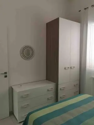 a bedroom with a dresser and a bed and a cabinet at Lovely apartment in Castellammare del Golfo in Castellammare del Golfo