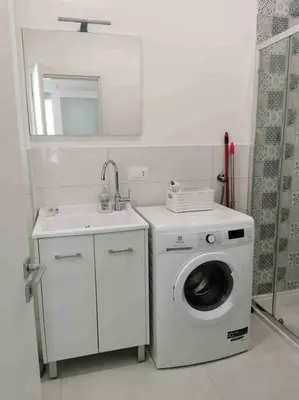 a bathroom with a washing machine and a sink at Lovely apartment in Castellammare del Golfo in Castellammare del Golfo