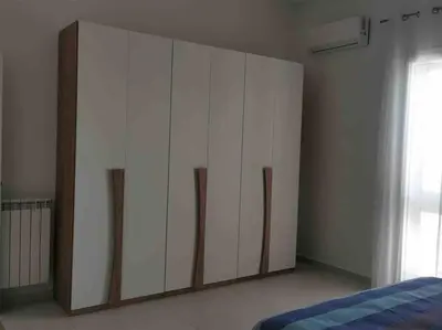 a large white cabinet in a room with a bed at Lovely apartment in Castellammare del Golfo in Castellammare del Golfo