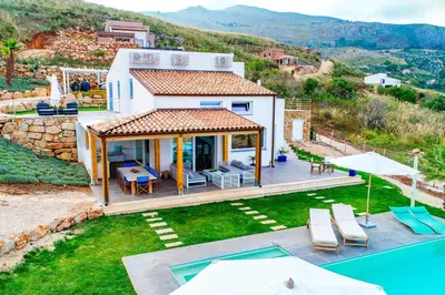 a villa with a swimming pool and a house at Villa Giulietta in Scopello