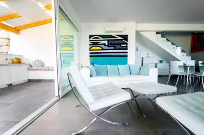 a living room with white furniture and a staircase at Villa Giulietta in Scopello