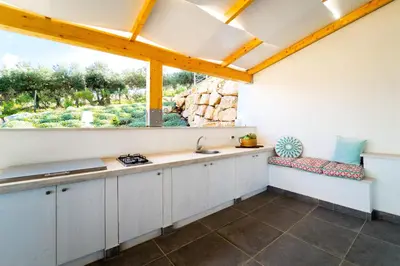a kitchen with white cabinets and a window at Villa Giulietta in Scopello