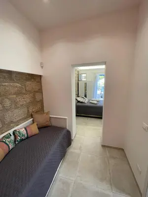 a bedroom with a bed and a living room at Casa Chiara in Isola delle Femmine