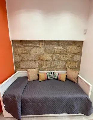 a bed in a room with a brick wall at Casa Chiara in Isola delle Femmine