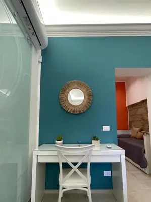 a blue wall with a white table and a mirror at Casa Chiara in Isola delle Femmine
