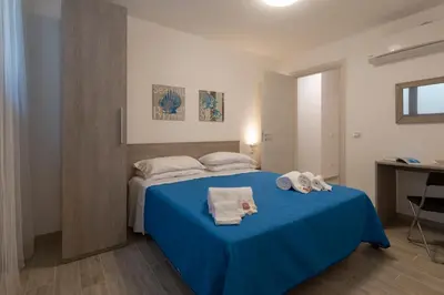 a bedroom with a blue bed with towels on it at I Tre Golfi - Via Salvatore Quasimodo in San Vito lo Capo