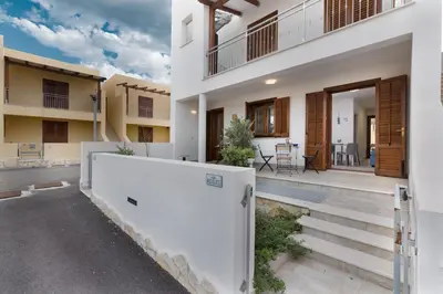 a house with a white fence in front of it at I Tre Golfi - Via Salvatore Quasimodo in San Vito lo Capo