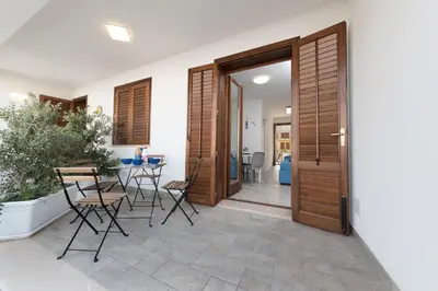 a door leading to a patio with chairs and a table at I Tre Golfi - Via Salvatore Quasimodo in San Vito lo Capo