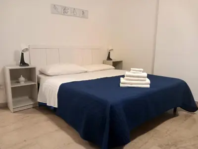 a bedroom with a bed with blue sheets and towels at Casa Carina in Centro in Palermo
