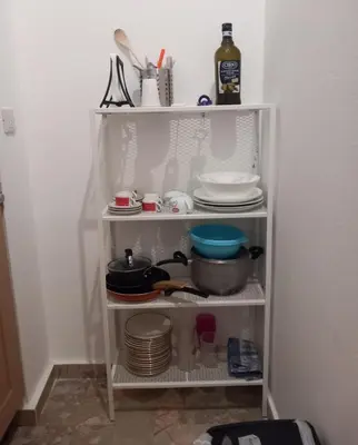 a white shelf filled with dishes and plates at Casa Carina in Centro in Palermo