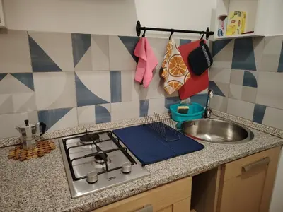 a kitchen counter with a stove and a sink at Casa Carina in Centro in Palermo