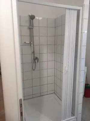 a shower in a white tiled bathroom at Casa Carina in Centro in Palermo
