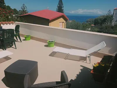 a patio with chairs and tables on a balcony at Da Carmen e Peppe in Santa Flavia