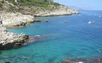 a large body of water next to a rocky island at Da Carmen e Peppe in Santa Flavia