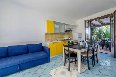 a living room with a blue couch and a table at Casa Vacanza Azzurra 4 in San Vito lo Capo