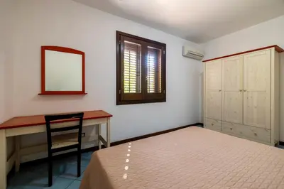 a bedroom with a bed and a desk and a mirror at Casa Vacanza Azzurra 4 in San Vito lo Capo