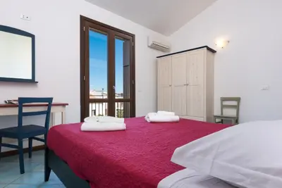 a bedroom with a bed and a desk and a chair at Casa Vacanza Azzurra 4 in San Vito lo Capo