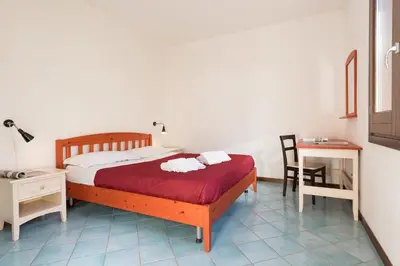 a bedroom with a bed and a desk and a chair at Casa Vacanza Azzurra 4 in San Vito lo Capo