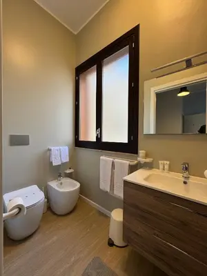 a bathroom with a toilet and a sink and a mirror at Turums B&B in Castellammare del Golfo