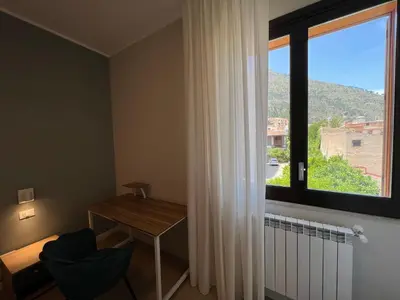 a room with a desk and a large window at Turums B&B in Castellammare del Golfo