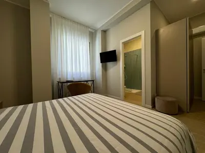 a bedroom with a large bed and a bathroom at Turums B&B in Castellammare del Golfo