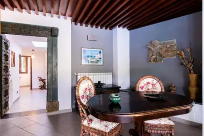a dining room with a wooden table and chairs at Mondello luxury villa con piscina in Mondello