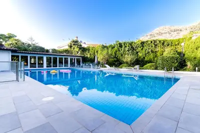 a large swimming pool with blue water at Mondello luxury villa con piscina in Mondello