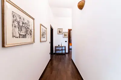 a hallway with white walls and paintings on the walls at Mondello luxury villa con piscina in Mondello
