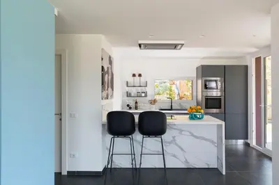 a kitchen with two black chairs at a counter at La Dolce Vita in Castellammare del Golfo