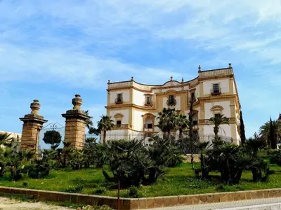 a large house with palm trees in front of it at Casa Vacanze L'Ortensia in Bagheria