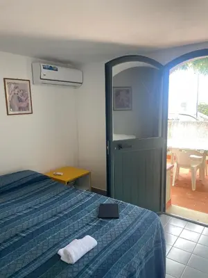 a bedroom with a bed and a door to a patio at villa Macari in San Vito lo Capo