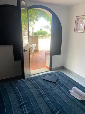 a bedroom with a bed and an open door to a patio at villa Macari in San Vito lo Capo