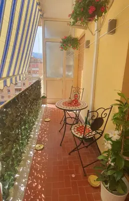 a patio with a table and chairs on a balcony at Rosa Apartament in Palermo