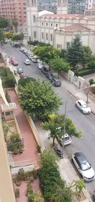 a city street with cars parked in a parking lot at Rosa Apartament in Palermo