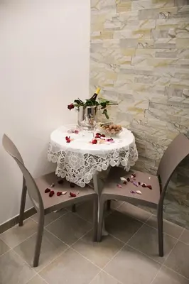 a table with two chairs and a table with flowers on it at B&B Le Ortensie in San Vito lo Capo