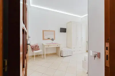 a white bathroom with a desk and a mirror at B&B Le Ortensie in San Vito lo Capo