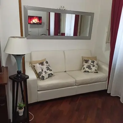 a living room with a white couch and a mirror at Liberty Casa Mazzini 34 in Palermo