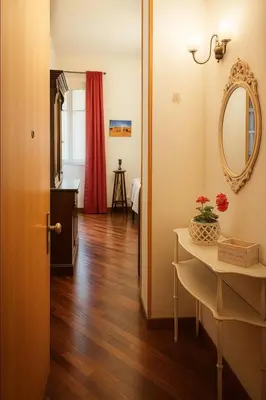 a room with a table and a mirror and a table with flowers on it at Liberty Casa Mazzini 34 in Palermo