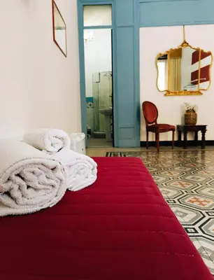 a small bedroom with a bed and a mirror at Teatro del Sole Cavour in Palermo