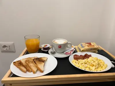 a tray with two plates of breakfast foods and a cup of coffee at Sant’Agostino Boutique Rooms in Palermo