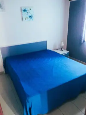 a blue bed with a blue bedspread in a bedroom at Purple House a Castellammare del Golfo in Castellammare del Golfo