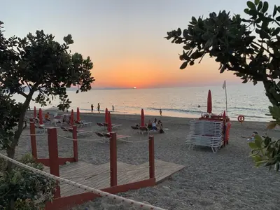 a group of chairs and umbrellas on a beach at Villa con piscina privata riscaldata ad uso esclusivo vicino Cefalù in Lascari