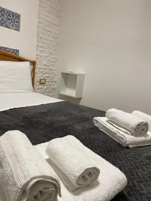 a bedroom with a bed with towels on it at Hostel Centro Città Basement in Palermo